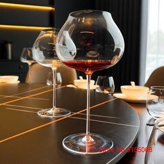 two wine glasses sitting on top of a wooden table