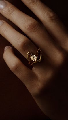 a person's hand with a gold ring on it