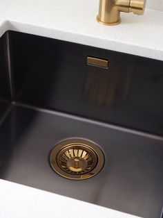 a kitchen sink with a gold faucet in it