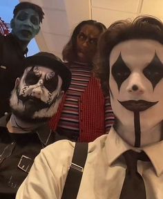 group of people dressed up as clowns with makeup on their faces and hands, all wearing black suspenders