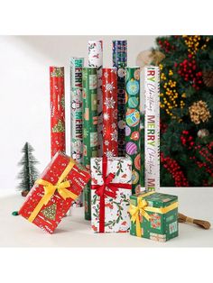 a stack of christmas wrapping paper next to a christmas tree with presents wrapped around it