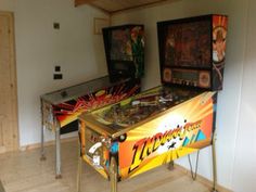 two pinball machines sitting in a room next to each other