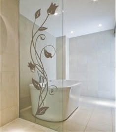 a bath tub sitting inside of a bathroom next to a wall mounted shower head with flowers on it