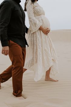 a pregnant couple walking in the desert