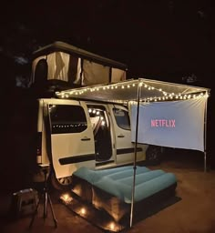 a white truck parked next to a tent with lights on it