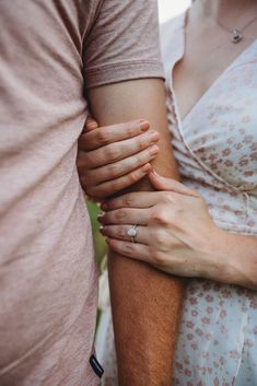 a man and woman holding each other's hands while standing next to each other