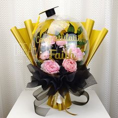 a bouquet of flowers with congratulations written on the front and side, sitting on top of a table