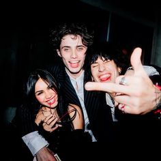 three young people posing for the camera with their fingers in the air