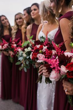 a group of women standing next to each other holding bouquets