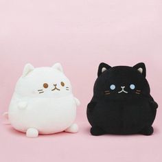 two black and white stuffed animals sitting next to each other on a pink background,