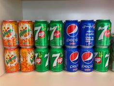 several cans of soda are lined up on a shelf