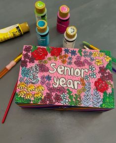 a book with the words senior year written on it next to crayons and markers