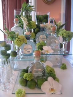 a table topped with lots of bottles and glasses filled with flowers on top of it