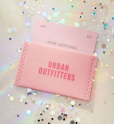 a pink credit card with the words urban outfitters on it surrounded by confetti