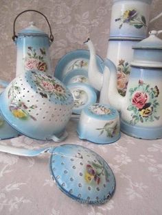 a table topped with blue and white dishes covered in floral designs on top of a table cloth