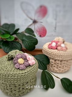 two crocheted baskets sitting next to each other on top of a white table