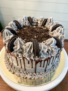 a cake with oreo cookies and cream frosting sitting on top of a wooden table