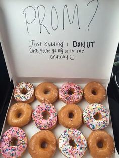 a box filled with donuts covered in frosting and sprinkles that say prom?