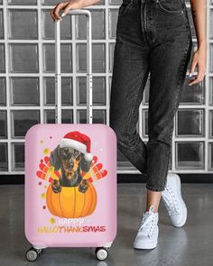 a woman standing next to a pink suitcase with a black and brown dog on it