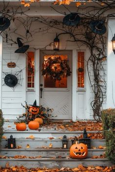 pumpkins are sitting on the steps in front of a white house with black decorations