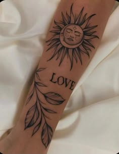 a sun with the word love on it's arm, and leaves around it