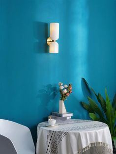 a table with a white cloth on it next to a blue wall