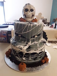 a three tiered cake decorated with icing and pumpkins on a white table