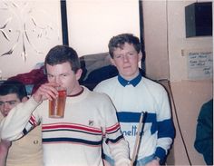 two young men are drinking beer together