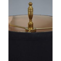 a brass table lamp with a black shade