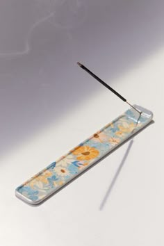 an object with a long stick sticking out of it's side on a white surface