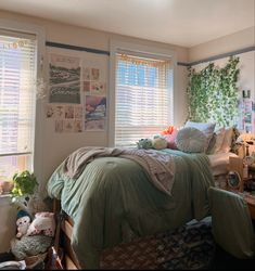 a bed room with a neatly made bed and lots of windows covered in green sheets