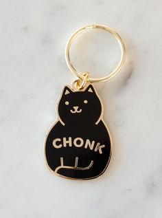 a black cat keychain with the word chonk on it's front