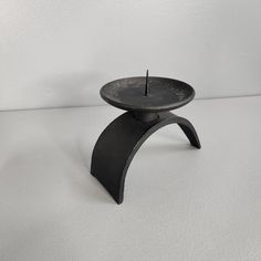 a small black candle holder sitting on top of a table