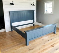 a bed with blue headboard and foot board in a room that has wood floors