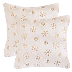 two white pillows with gold snowflakes on them