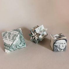 two origami blocks with one dollar bill on top and the other folded up