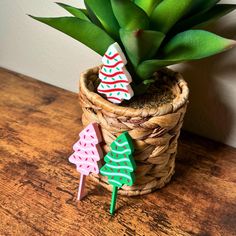 a potted plant sitting on top of a wooden table next to green leaves and decorations