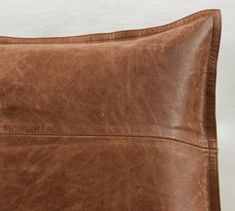 a brown leather pillow sitting on top of a white table