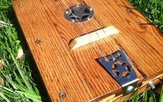 a wooden box sitting in the grass on top of it's side with two holes