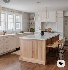 a large kitchen with white cabinets and wooden flooring is featured in this postcard