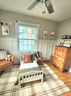 a bed room with a neatly made bed next to a dresser and a window in it