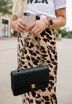 Leopard print is trending this summer and Uptown With Elly Brown shares how to style this trend. This leopard print midi skirt pairs perfectly with a graphic tee and heels. Follow for more elevated outfit ideas, summer fashion trends, and style guides. Summer Maternity Clothes, Midi Skirt Summer, Leopard Print Midi Skirt, Pregnancy Outfit, Vintage Chanel Bag, Summer Maternity, Accessories Aesthetic