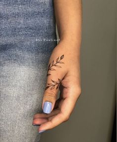 a woman's hand with a small tattoo on it