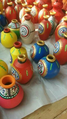 many colorful vases are lined up on the table with white wax paper underneath them