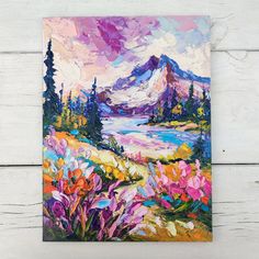 a painting of flowers and mountains on a white wooden wall