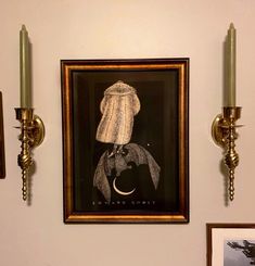 a painting on the wall next to two candles