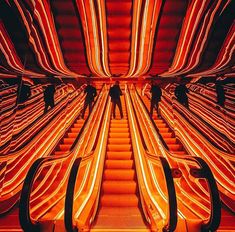 an escalator with neon lights in the background