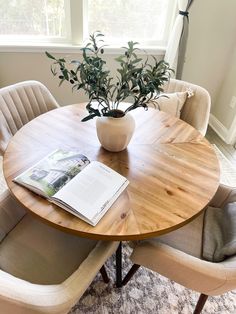 a round wooden table with chairs around it