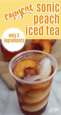 an iced drink in a plastic cup with ice and sliced peaches on the side