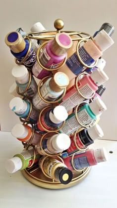 a gold container filled with lots of different types of paint and other things on top of it